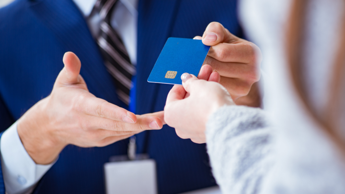 persona mostrando y entregando una tarjeta de crédito