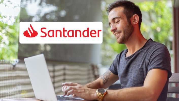 Hombre sonriente utilizando su computadora portátil desde una terraza mientras revisa su Cuenta Débito Santander.