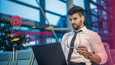 persona sentada con anteojos en una mano y la otra frente a la computadora, analizando el préstamo personal del Banco Compartamos