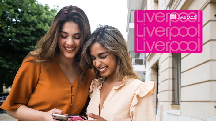 Dos mujeres mirando el teléfono celular sonriendo a la tarjeta de crédito Liverpool