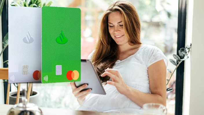 mujer sonriendo a la computadora mirando la tarjeta de crédito santander como u