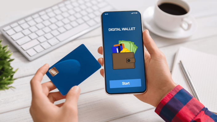 Aplicación de billeteras digitales en un smartphone junto a una tarjeta de crédito, representando la digitalización de pagos.